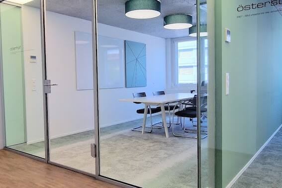 Sitzungszimmer mit Whiteboard und akustikoptimierender Pinnwand von Impact Acoustic und Interface Teppich in grün-grau.
