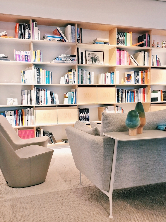 Informelle Austauschzone bei Vitra mit gemütlicher Sitzgelegenheit und Bibliothek mit integrierten Schliessfächer.