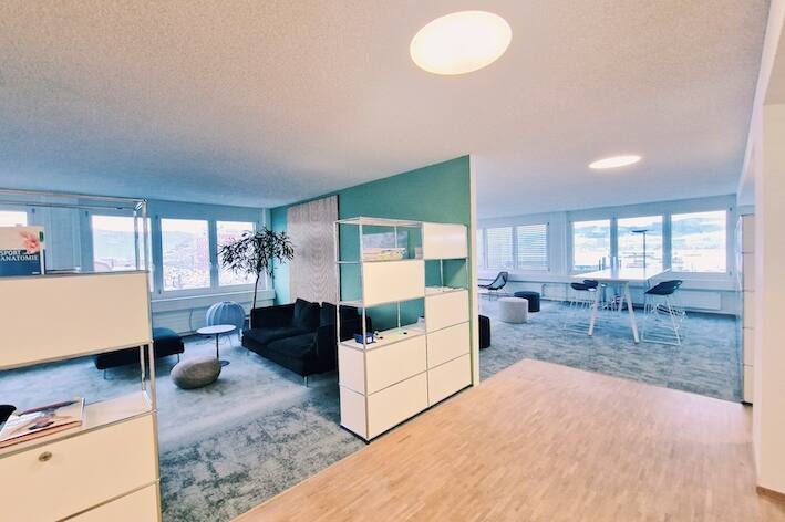 Library und Innovationsraum in zukunftsorientiertem Bürokonzept Multispace mit grüner Wand, WoodUpp-Panel und grauem Interface Teppich